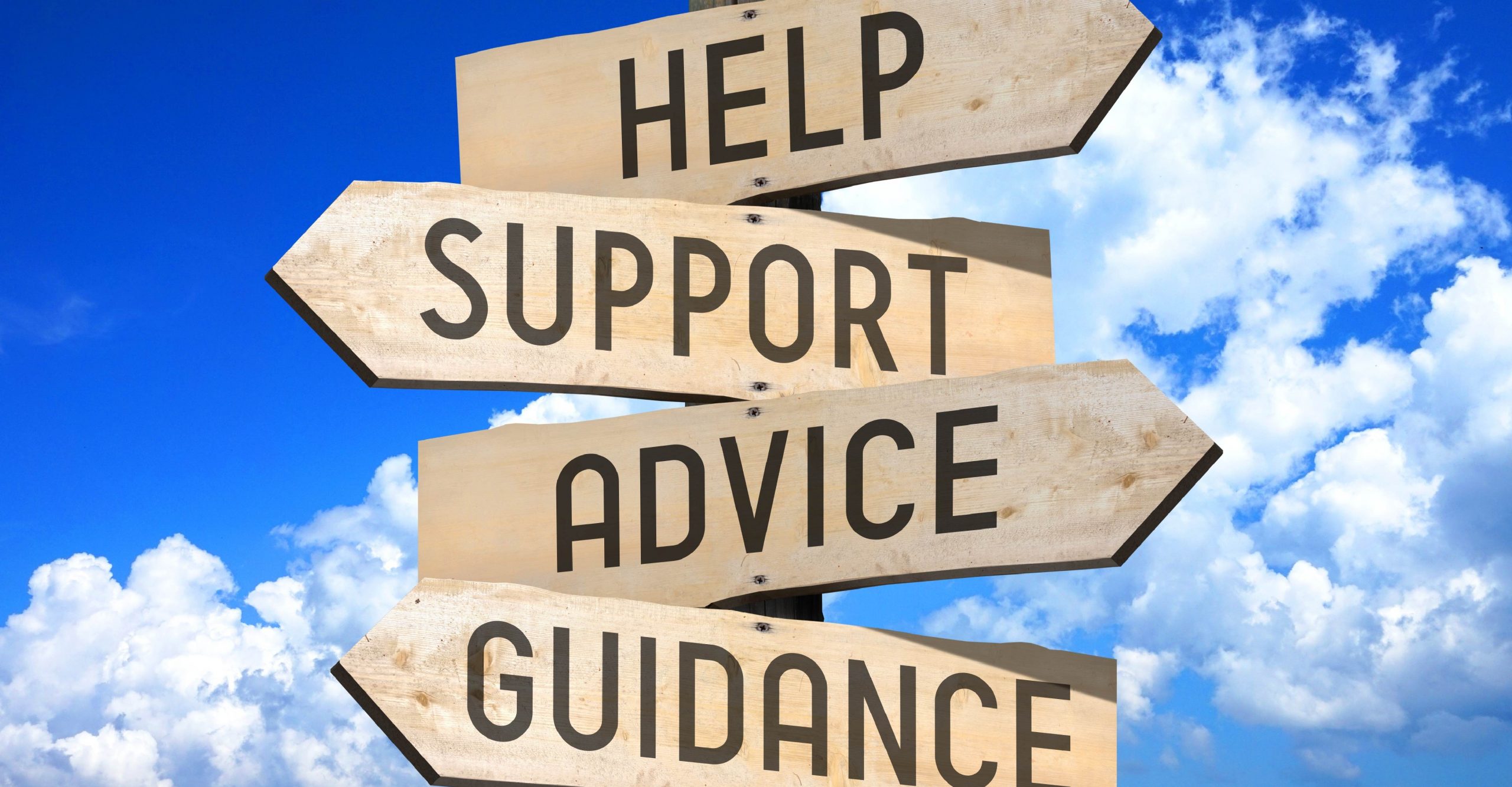 Wooden signposts against a blue sky with clouds, displaying the words "HELP," "SUPPORT," "ADVICE," and "GUIDANCE" in black capital letters.